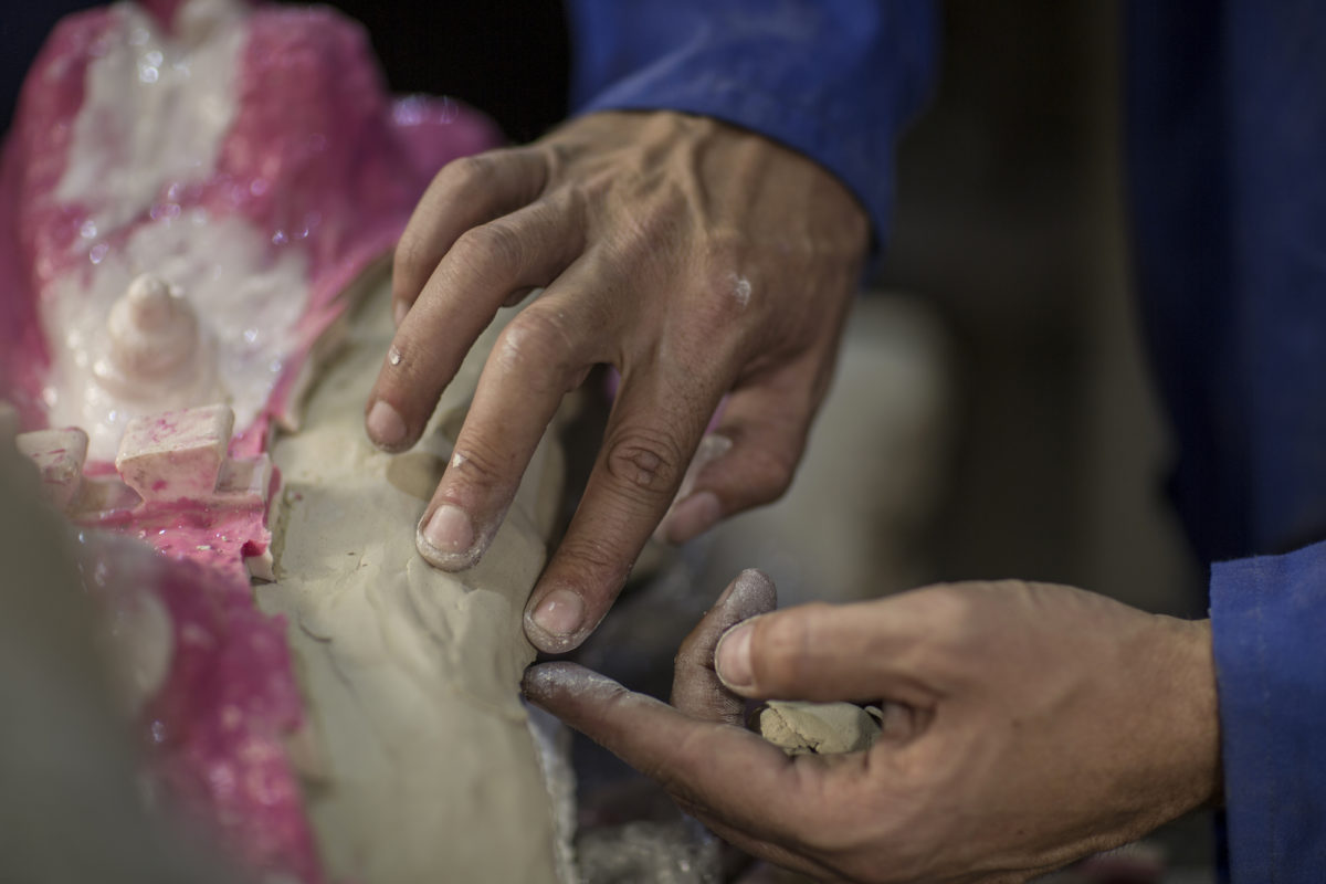 Cropped view of sculptor in artist studio creating plaster cast sculpture Cape Town, South Africa, man working in sculpting studio, working with mold