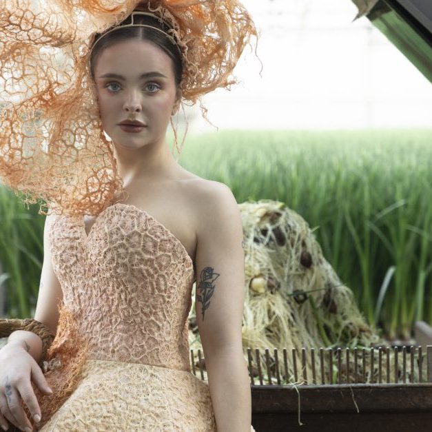 New, natural fibre grass root textile is used to grow dress and worn by a model on a farm setting